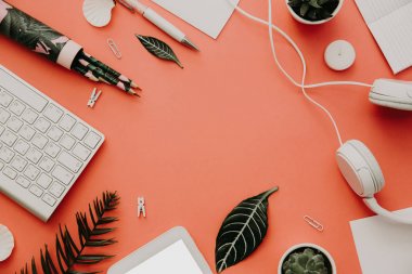 Düz office kümesi kaynakları, kulaklık ve klavye pastel arka plan üzerinde yatıyordu. Üstten Görünüm masa üzerinde çeşitli ileti örneği üzerinde. Yaratıcı çalışma alanı arka plan 