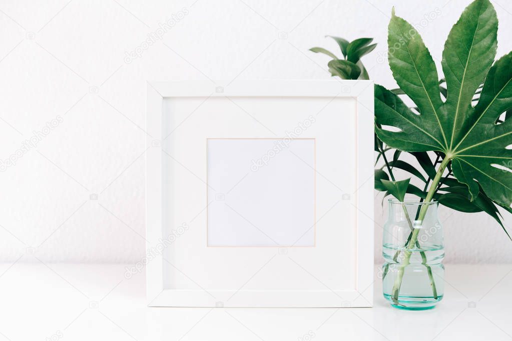Minimalism mockup white frame with green leaves in vase .  Home decor, Styled still life