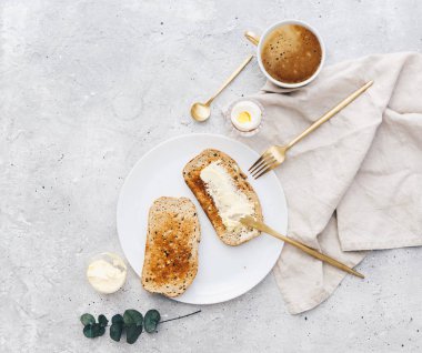 Ekmek dilimleri ile bitişik tereyağı ve tereyağı bıçağı rustik keten masa örtüsü üzerinde. Üstten Görünüm, düz yatıyordu 