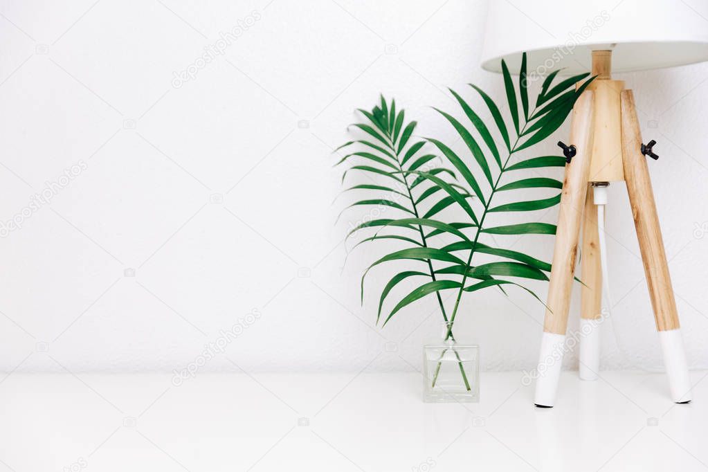 Nordic living room. Scandinavian lamp and tropical leaves. Eclectic Minimal home decor