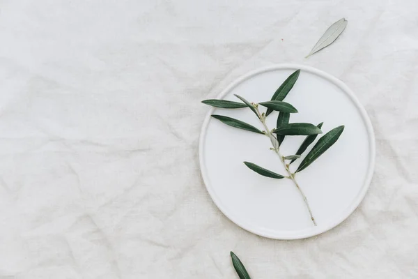 Flat Lay Olive Branch White Plate Linen Tablecloth Organic Rustic — Stock Photo, Image