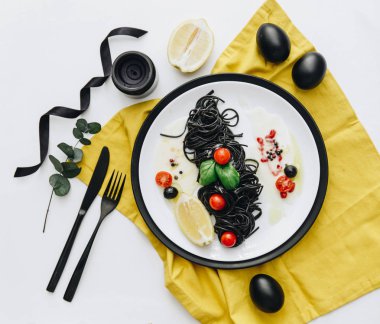 Siyah spagetti Bazilikası'nın ve domates masada. Siyah Paskalya yumurtaları 