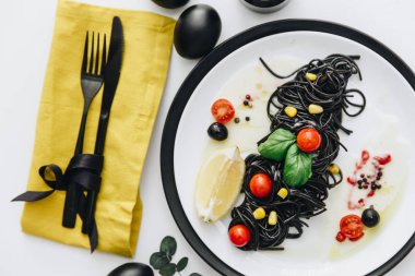 Siyah spagetti Bazilikası'nın ve domates masada. Siyah Paskalya yumurtaları 