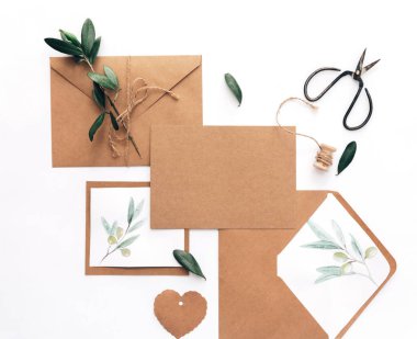Mockup düğün davetiyesi düz yatıyordu. Kraft kağıt arka plan üzerinde zeytin brunch ile