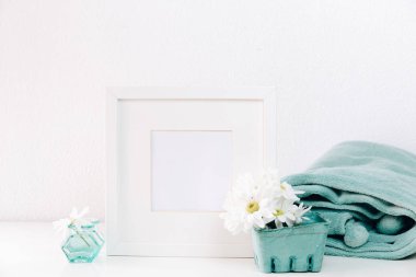 Mockup beyaz bir çerçeve ve hafif bir arka plan üzerinde bir vazoda yaz çiçek