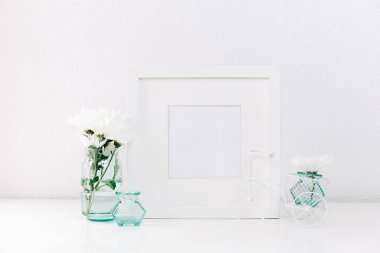 Mockup beyaz bir çerçeve ve hafif bir arka plan üzerinde bir vazoda yaz çiçek