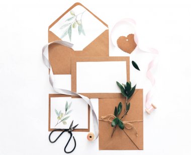Mockup düğün davetiyesi düz yatıyordu. Kraft kağıt arka plan üzerinde zeytin brunch ile