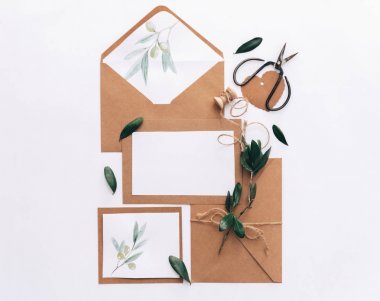 Mockup düğün davetiyesi düz yatıyordu. Kraft kağıt arka plan üzerinde zeytin brunch ile