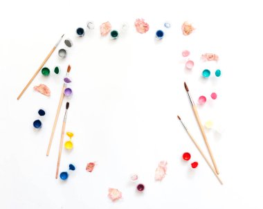 Sanatçı çalışma alanı. Suluboya ve beyaz arka planda fırçalar. Düz yatıyordu, en iyi görünümü