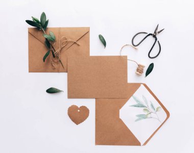 Mockup düğün davetiyesi düz yatıyordu. Kraft kağıt arka plan üzerinde zeytin brunch ile
