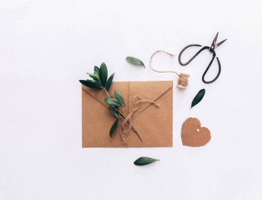 Mockup düğün davetiyesi düz yatıyordu. Kraft kağıt arka plan üzerinde zeytin brunch ile