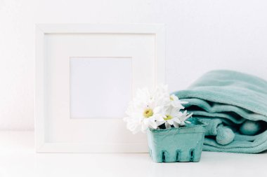 Mockup beyaz bir çerçeve ve hafif bir arka plan üzerinde bir vazoda yaz çiçek