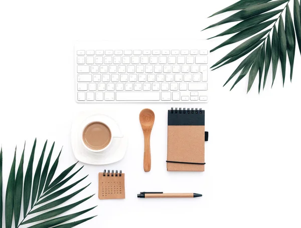 Minimal Office desk table with stationery set, supplies and palm leaves. Top view with copy space, creative flat lay.