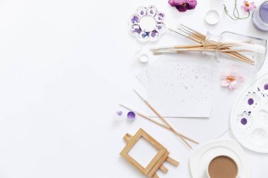 Beyaz arka plan üzerinde sanatçı çalışma alanı ile boyalar, palet, Boya fırçaları