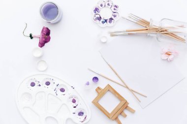 Beyaz arka plan üzerinde sanatçı çalışma alanı ile boyalar, paletleri, Boya fırçaları