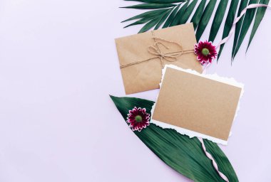 Düz yatıyordu yaz kompozisyon. Yaratıcı kavramı tropikal yaprak ve davetiyeler. Üstten görünüm, kopya alanı