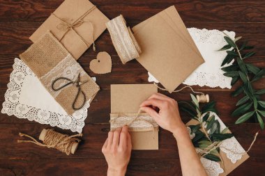Düğün daveti yaparken kadın eller. Rustik DIY kavramı. El yapımı el yapımı ürünleri düz lay