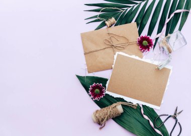 Düz yatıyordu yaz kompozisyon. Yaratıcı kavramı tropikal yaprak ve davetiyeler. Üstten görünüm, kopya alanı