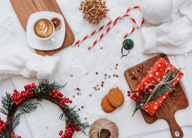 Yılbaşı ya da yeni yıl arkaplanı düzleştirilmiş. Noel süslemeleri, çelenkler, kahve fincanları. Sıcak kış. Blogcular için üst görünüm 