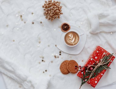Noel kış arkaplanı. Bir fincan kahve, sıcak örülmüş süveter, yatağın üzerinde - rahat ev hala hayat, üst manzara