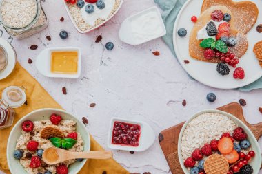 Düz kompozisyon, yulaf ezmeli yulaf lapası, meyveli müsli, sağlıklı gıda konsepti. Üst görünüm