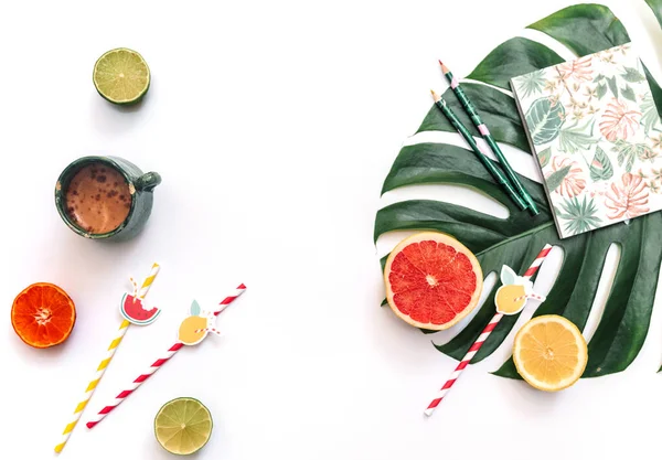 Flat lay of minimal workspace, Top view of fresh summer fruits composed on top of bright green Monstera leaf