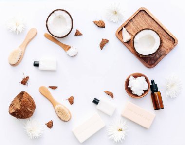 Beyaz arka planda hindistan cevizi parçaları ve vücut bakım ürünleriyle organik sağlıklı hindistan cevizi ezmesi.