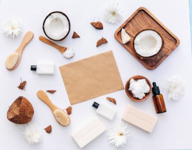 Beyaz arka planda hindistan cevizi parçaları ve vücut bakım ürünleriyle organik sağlıklı hindistan cevizi ezmesi.