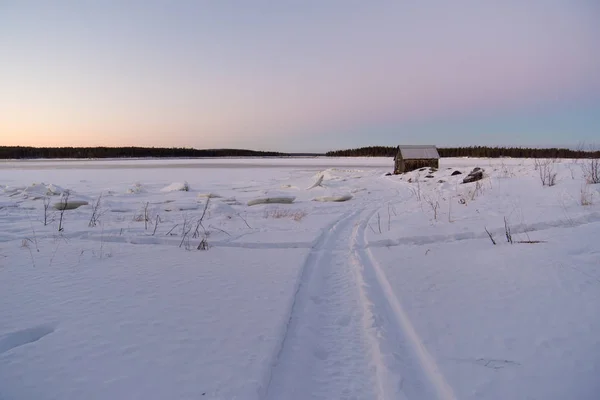 White sea. House on the coast. Winter