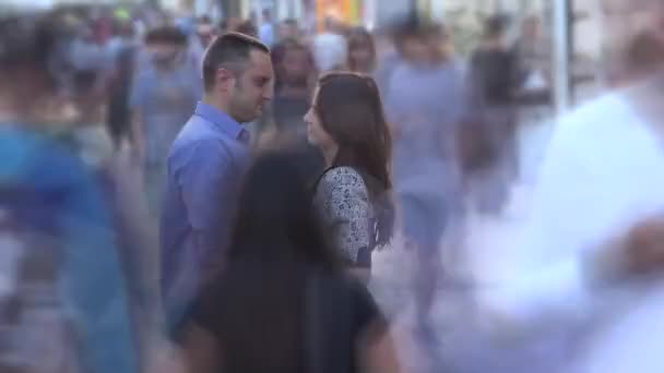 Young lovers couple stand still together in middle of fast moving crowded street, timelapse