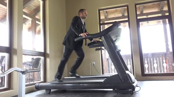 Man with suit running on gym machine, work break, running to succes
