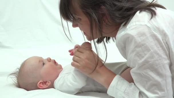Látszó-on fekvő baba, mosolygós arcok varázslatos kommunikációs fiatal anya