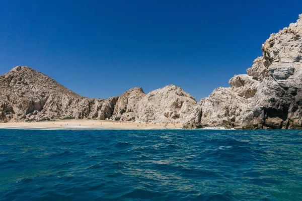 Küçük plaj ve okyanus çevreleyen kayalık uçurum