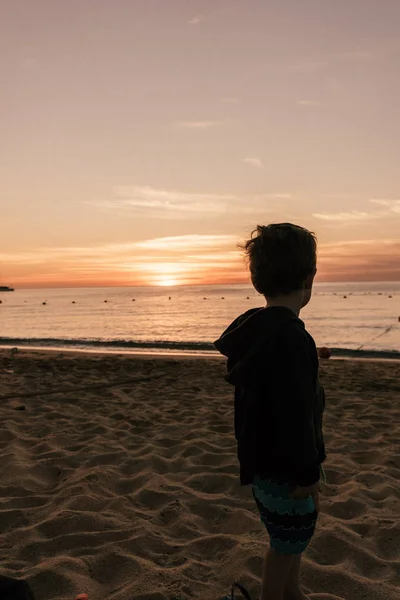 Bir plajda güneşin doğuşunu izlemek yürümeye başlayan çocuk