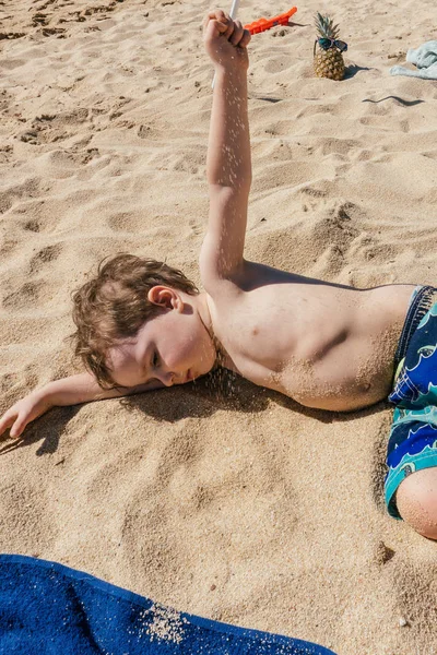 Yürümeye başlayan çocuk kum yalan ve kumsalda oynarken