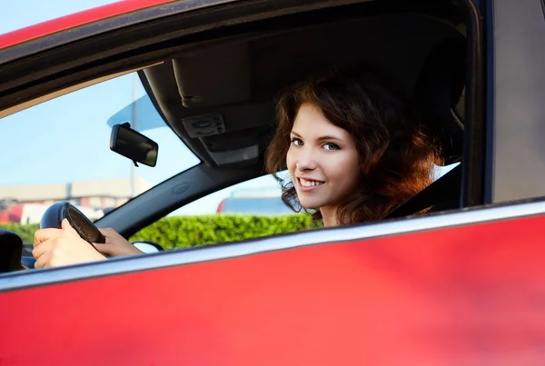 Jovem mulher dirigindo um carro novo — Fotografia de Stock