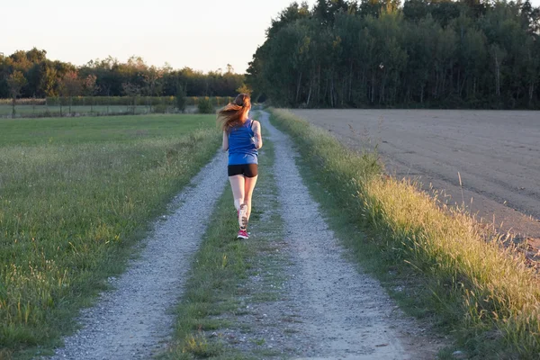 Fit femme courir vite, l'entraînement au soleil brillant — Photo