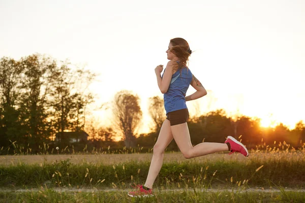 フィット女性高速を実行して、明るい日差しの中でトレーニング — ストック写真