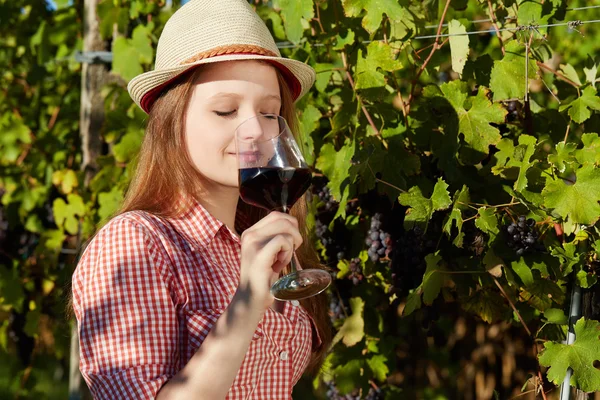 Młoda kobieta szczęśliwa trzymając kieliszek wina w polach winogron — Zdjęcie stockowe