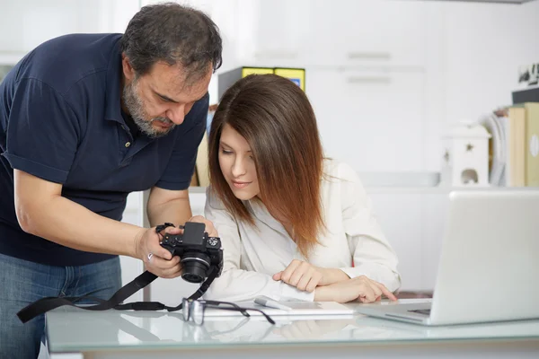 Young female photographer learning by a master photographer — Stock Photo, Image
