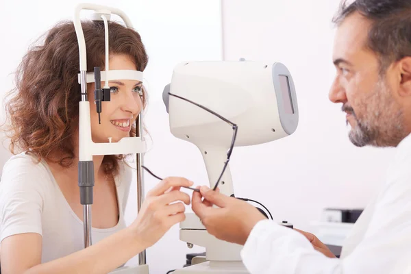 Optometrist na sala de exame com mulher na cadeira — Fotografia de Stock