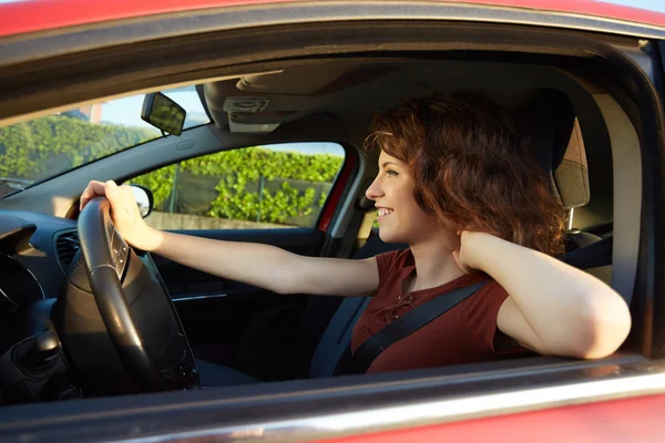 Jovem mulher dirigindo seu carro novo — Fotografia de Stock