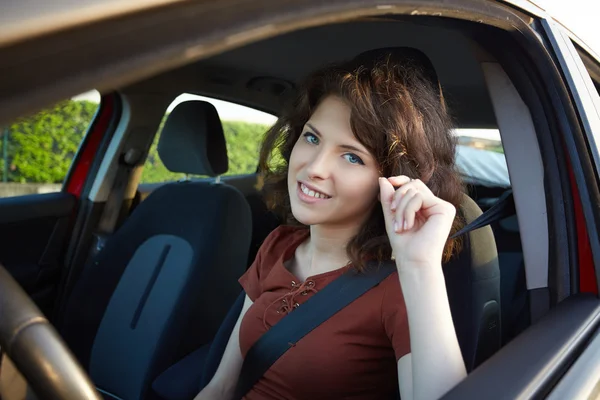 Mujer joven conduciendo un coche nuevo — Foto de Stock