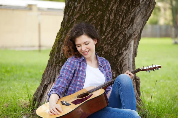 Vrouw spelen gitaar in park — Stockfoto