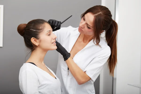 Cosmetologist aplicando a composição permanente nas sobrancelhas — Fotografia de Stock