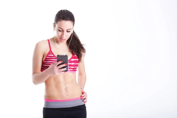 Mujer en forma sonriente con teléfono inteligente — Foto de Stock