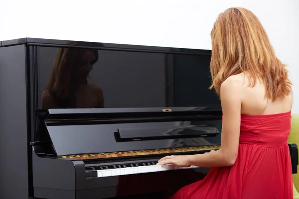 Joyeux jeune femme jouant du piano à l'intérieur . — Photo