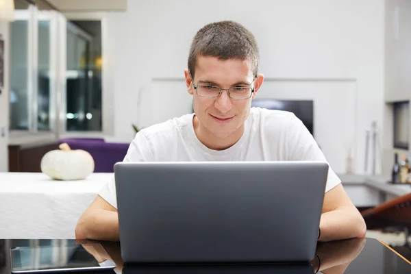 Młody człowiek z okularów, działanie jego notatnik — Zdjęcie stockowe