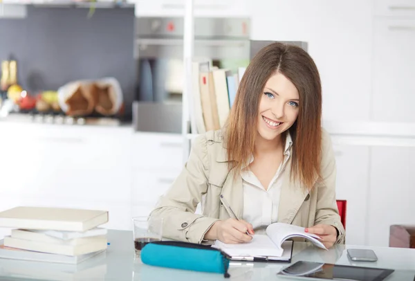 Estudiante estudiando con portátil y tomando notas en un escritorio en casa — Foto de Stock