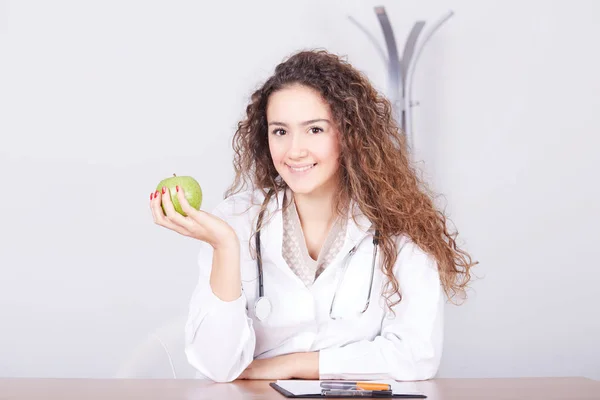 Nő orvos, egy zöld almával. — Stock Fotó